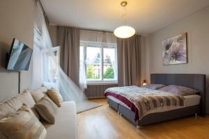 a bedroom with a bed and a couch and a window at Libušina Villa in Kutná Hora