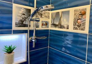 a blue tiled bathroom with a shower at Sleeping Sailors Boutique Hotel in Siófok