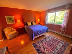 een slaapkamer met oranje muren en een bed en een raam bij F6 Townhome with golf course and mountain views in Bretton Woods next to Mt Washington HotelF6 in Carroll