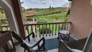 ein Balkon mit zwei Stühlen und Blick auf einen Garten in der Unterkunft Rajski vrt in Vrdnik
