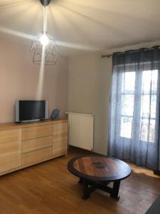 a living room with a coffee table and a tv at L'embellie in Treffort