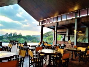a restaurant with tables and chairs and a view of the water at Symphony Samudra Beachside Jungle Resort And Spa in Port Blair