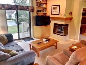 a living room with a couch and a fireplace at G4 Modern home with AC within walking distance of golf course and Mt Washington Hotel in Carroll