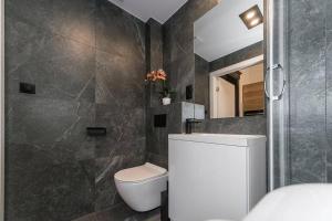 een badkamer met een wit toilet en een douche bij Studio Matejki D in Bielsko-Biala