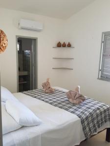 a bedroom with two stuffed animals sitting on a bed at Vila Yoga - Kitesurf Pontal de Maceió in Fortim