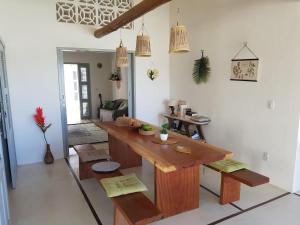 a dining room with a wooden table and benches at Vila Yoga - Kitesurf Pontal de Maceió in Fortim