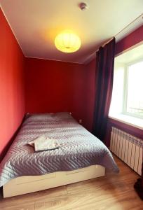 a bedroom with a bed in a red wall at Студии на улице 850 летия in Vladimir