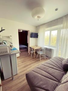 a room with a bed and a kitchen with a table at Студии на улице 850 летия in Vladimir