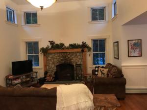 a living room with a fireplace and a couch at MO Private home in beautiful wooded setting - close to Bretton Woods AC in Carroll