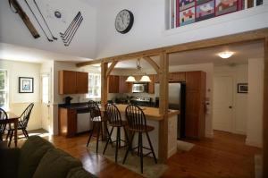 cocina y sala de estar con barra y sillas en MO Private home in beautiful wooded setting - close to Bretton Woods AC, en Carroll