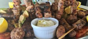 a plate of food with meat and dipping sauce at Ariston Hotel in Athens