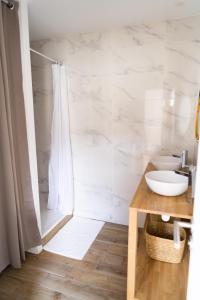 een badkamer met een douche, een wastafel en een toilet bij Appartement cosy dans une longère de caractère in Saumur