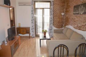 uma sala de estar com um sofá e uma parede de tijolos em Rustic 2 bedroom apartment Poble Sec em Barcelona