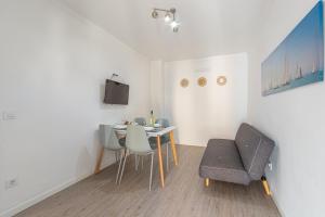 Habitación con mesa, sillas y TV. en Apartments Playa, en Alcudia
