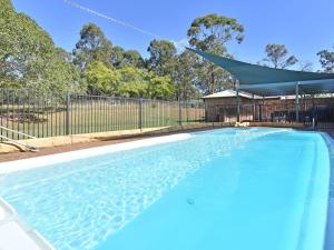 a swimming pool in a yard with a fence at Blaxlands Homestead - Nothing is closer opposite Hope Estate with Wifi and Pool plus Fireplace in Pokolbin