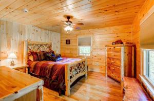 ein Schlafzimmer mit einem Bett in einer Holzhütte in der Unterkunft OE Beautiful modern log home on 17 acres private views fire pit Ping Pong AC in Whitefield