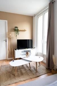 a living room with a tv and a white coffee table at Appartement cosy dans une longère de caractère in Saumur