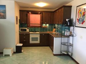 a kitchen with wooden cabinets and a white refrigerator at Porto San Paolo Sea Villa in Porto San Paolo