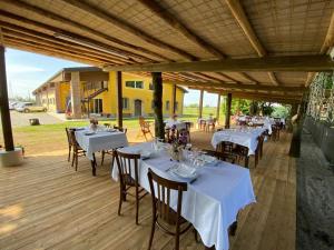 una zona pranzo con tavoli e sedie su una terrazza in legno di Agriturismo Castolda a Treviglio