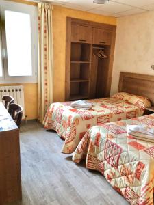 a room with two beds and a window at Le Sans Souci in Jausiers