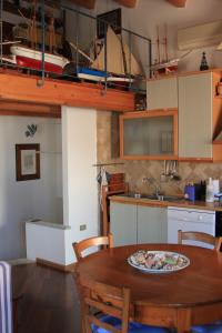 une cuisine avec une table en bois et une plaque de cuisson. dans l'établissement Casa Ziguratt Carloforte, à Carloforte