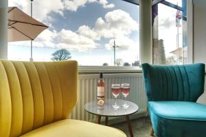 una mesa con dos copas y una botella de vino en Palm Court, Seafront Accommodation en Skegness