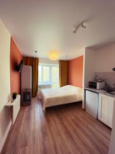 a bedroom with a bed and a kitchen in it at Студии на улице 850 летия in Vladimir