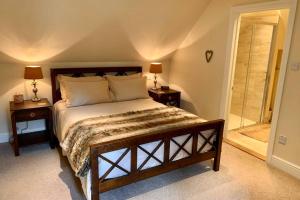 Wickham Bishops的住宿－The Cartlodge，一间卧室配有一张带2个床头柜的大床