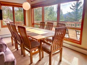 jadalnia ze stołem i krzesłami oraz oknem w obiekcie W4 Comfortable and spacious Bretton Woods condo with ski slope views, fireplace and fast wifi! w mieście Carroll