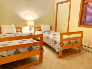 1 dormitorio con 2 camas individuales y ventana en W4 Comfortable and spacious Bretton Woods condo with ski slope views, fireplace and fast wifi!, en Carroll