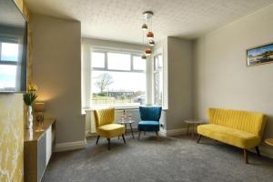 a waiting room with chairs and a table and a window at Palm Court in Skegness