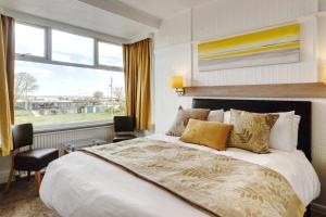 a bedroom with a large bed and a large window at Palm Court in Skegness