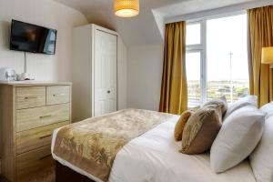 a bedroom with a large bed and a window at Palm Court in Skegness