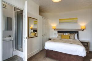 a bedroom with a bed and a sink and a mirror at Palm Court in Skegness