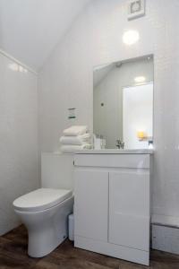a white bathroom with a sink and a toilet at Palm Court in Skegness