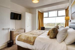 a bedroom with a large bed and a window at Palm Court in Skegness