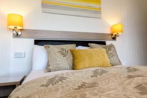a bedroom with a bed with two lights on the wall at Palm Court in Skegness