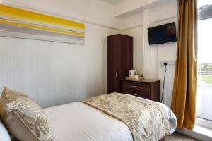 a bedroom with a bed and a window at Palm Court in Skegness