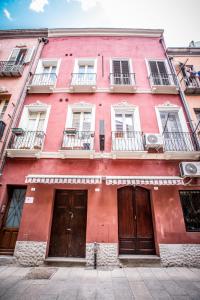 un edificio rosso con due porte e finestre di Apart Suites Marina a Cagliari