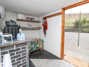 een keuken met een deur naar een patio bij The Shepherd's Bothy on Blaenbrynich Farm in Brecon