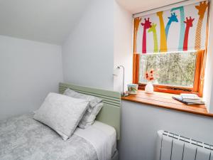 um quarto com uma cama e uma janela em The Shepherd's Bothy on Blaenbrynich Farm em Brecon
