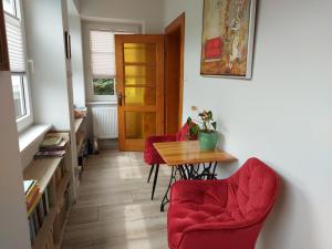 Pokój ze stołem i 2 czerwonymi krzesłami w obiekcie Apartament na Rybnej w Polanicy Zdroju
