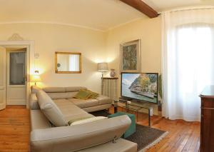 Il comprend un salon doté d'un canapé et d'une télévision à écran plat. dans l'établissement Claudio Appartamenti, à Bardolino