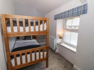 1 dormitorio con 2 literas y ventana en Ferndale, en Pwllheli