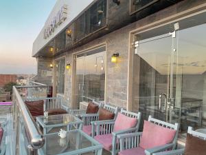 - un balcon avec des chaises et des tables dans un bâtiment dans l'établissement Best View Pyramids Hotel, au Caire