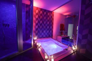 a purple bathroom with a tub with lights in it at Residenza San Lorenzo in Naples