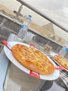 a pizza on a white plate on a table at Best View Pyramids Hotel in Cairo