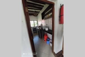 a view of a kitchen from the hallway of a house at Dadida‘s Pool Cottage in Diani Beach