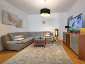 uma sala de estar com um sofá e uma televisão em Villa Bloom Garden em Rupići