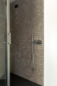 a shower in a bathroom with a tile wall at Residenza San Lorenzo in Naples